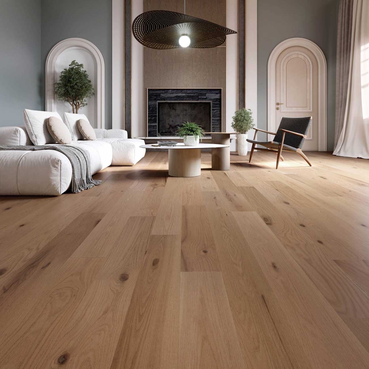 Warm oak hardwood floors in a bright living room with a linen sofa and stone fireplace