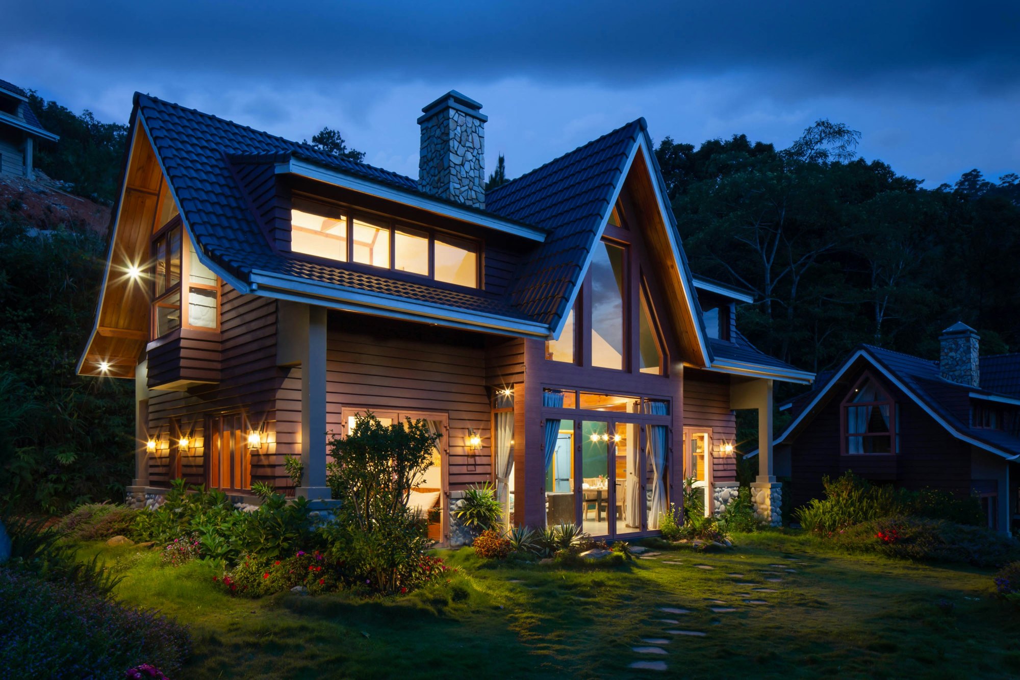 A home at dusk with a new roof and stone chimney