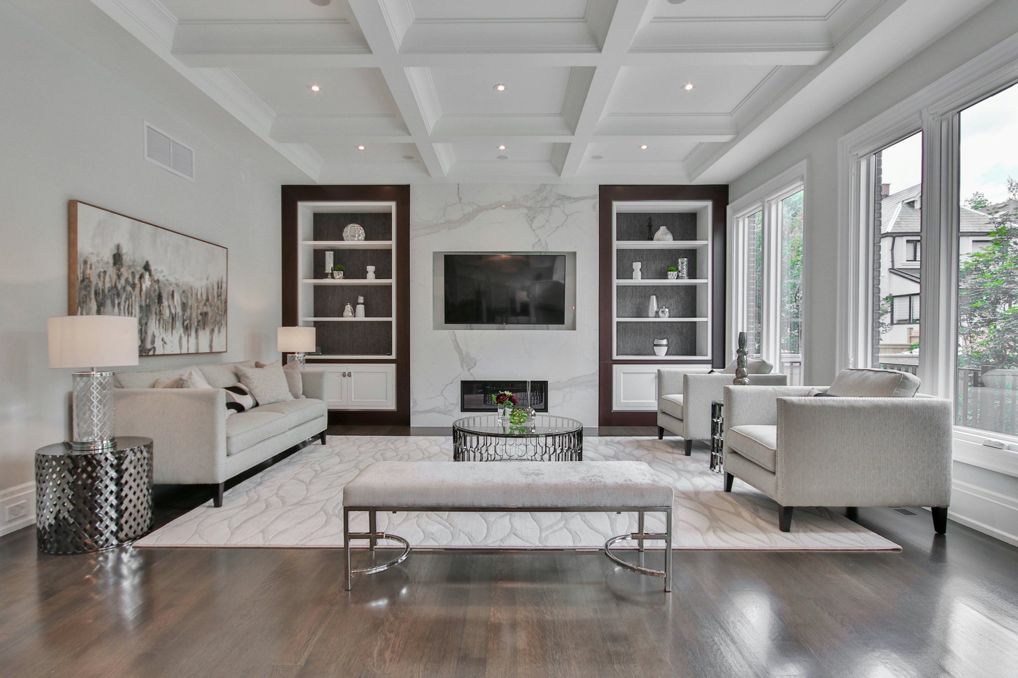 Living room with coffered ceiling, marble fireplace wall and built-ins